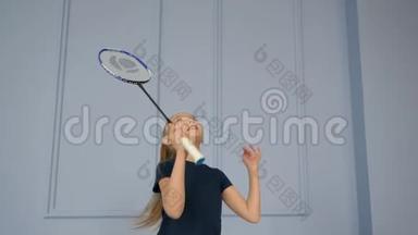 开朗的少年女孩在灰色背景下<strong>打羽毛球</strong>。 慢动作